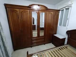 Dormitorio clásico madera oscura y mármol