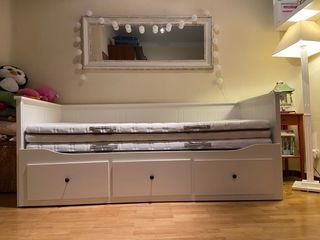 Cama blanca con cajones de madera