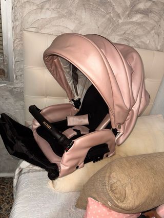 Carro de bebé rosa y dorado