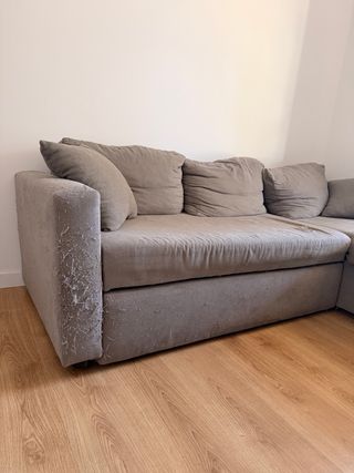 Sofá modular gris con daños de gato