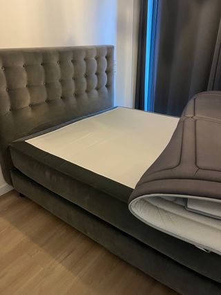 Cama tapizada gris con cabecero capitoné