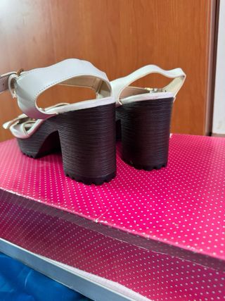 Sandalias blancas con tacón y hebilla dorada