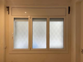 Ventana blanca con manilla y persiana