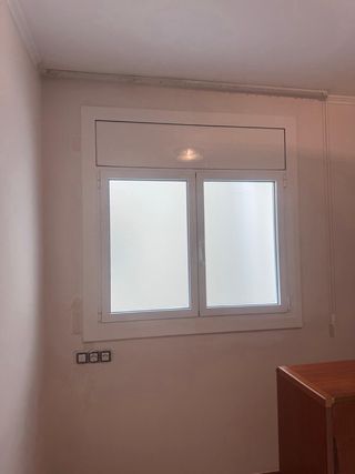 Ventana blanca con manilla y persiana