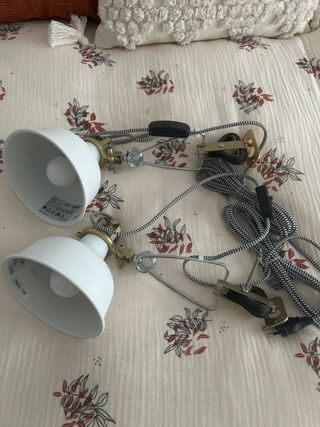 Focos de pared con pinza dorados y blancos.