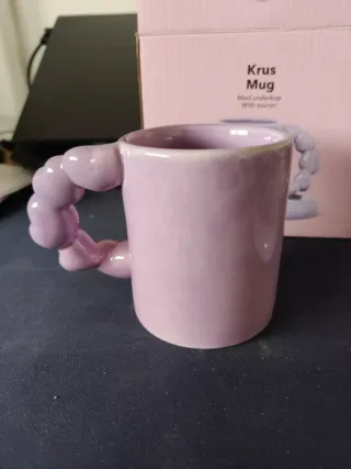 Tazza viola con piattino a forma di cuore.