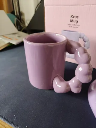 Tazza viola con piattino a forma di cuore.