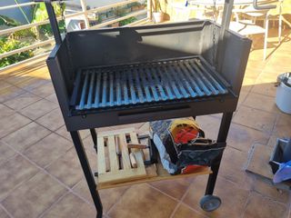 Barbacoa negra con funda y detalles madera