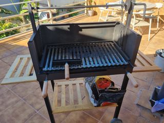 Barbacoa negra con funda y detalles madera