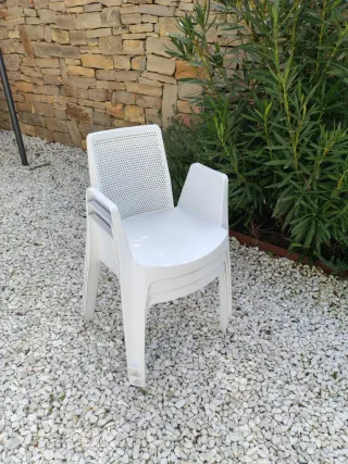 Sillas de jardín blancas de plástico.