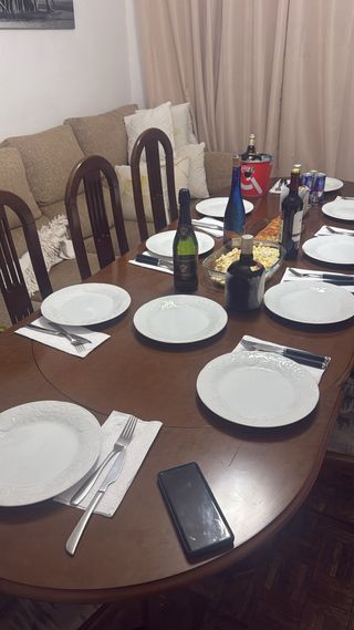 Mesa de comedor ovalada de madera extensible.