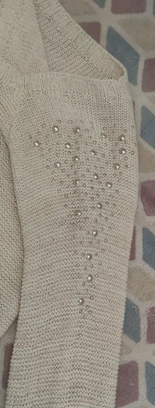 Jersey de mujer blanco con perlas doradas.
