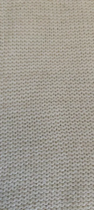 Jersey de mujer blanco con perlas doradas.