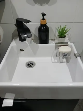 Lavabo de cerámica con grifo negro