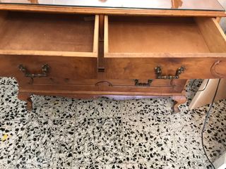 Cómoda antigua de madera con tapa de cristal.