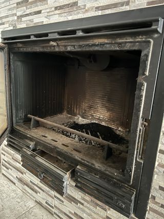 Estufa de leña con ventilación forzada empotrada.