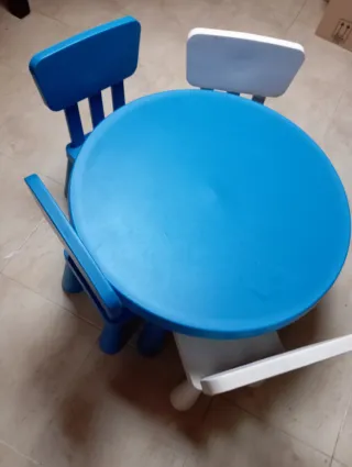 Mesa redonda con cuatro sillas y dos taburetes.