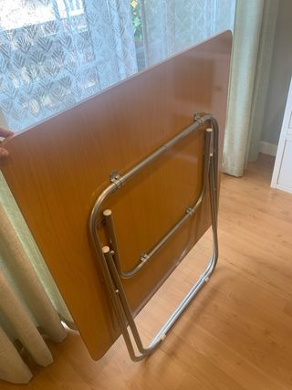 Mesa plegable con acabado en madera y metal.