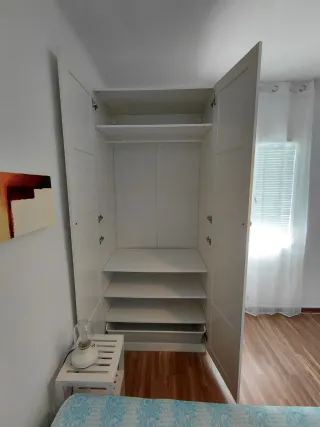 Cama y armario de habitación.