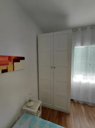 Cama y armario de habitación.