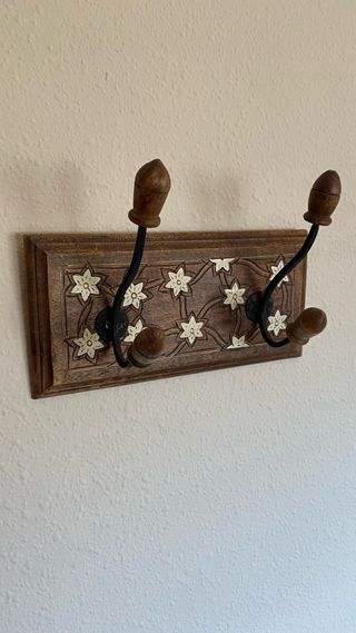 Perchero de madera con adornos florales