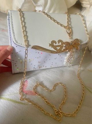 Bolso blanco elegante con cadena dorada y colgante