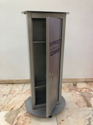Pie de vitrina Casio acero con ruedas y cerradura.