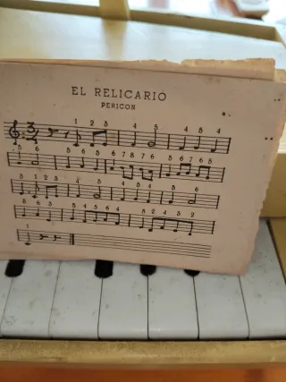 Antiguo piano de juguete con partitura
