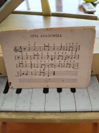 Antiguo piano de juguete con partitura