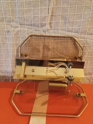 Lámpara de pared dorada y transparente