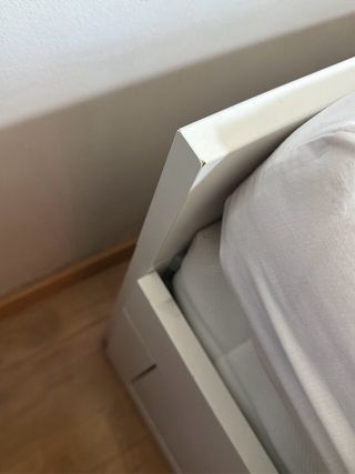 Cama blanca con cajones de madera