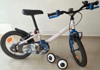 Bicicleta infantil con ruedines y casco