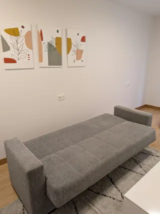 Sofá gris, mesa elevable y alfombra