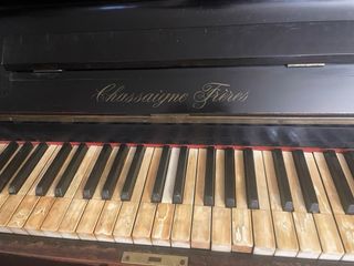 Piano Vertical Negro con teclas de marfil.