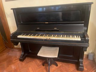 Piano Vertical Negro con teclas de marfil.