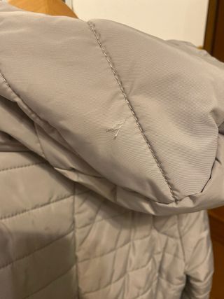 Abrigo gris acolchado con capucha.