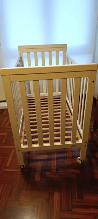 Cuna de madera blanca con ruedas