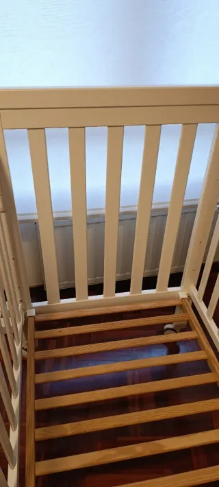 Cuna de madera blanca con ruedas