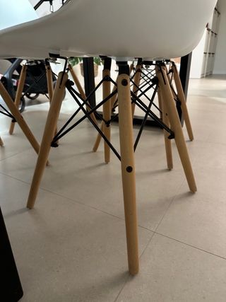 Sillas blancas de plástico y patas de madera