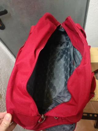Mochila de viaje roja con ruedas y asa