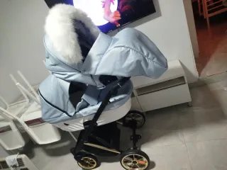 Carro de bebé azul con detalles dorados