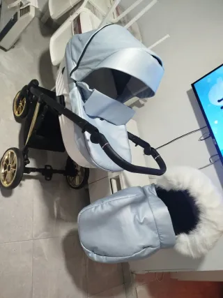 Carro de bebé azul con detalles dorados