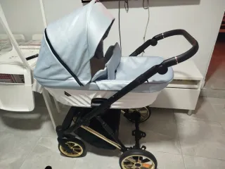 Carro de bebé azul con detalles dorados