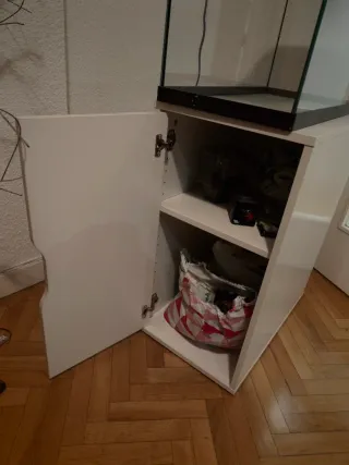 Mueble blanco con dos baldas y puerta.