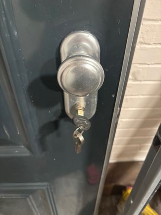 Puerta de casa con pomo y llaves