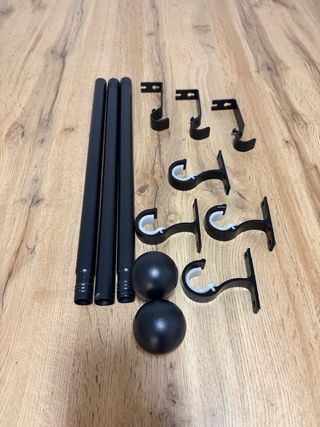 Barra de cortina negra con soportes.