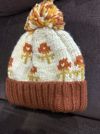 Gorro tejido con pompón y flores