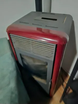 Chimenea de pellet gris y roja en funcionamiento.
