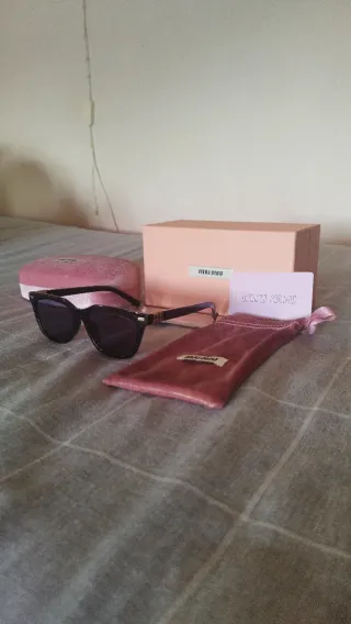 Gafas de sol Miu Miu negras y doradas mujer