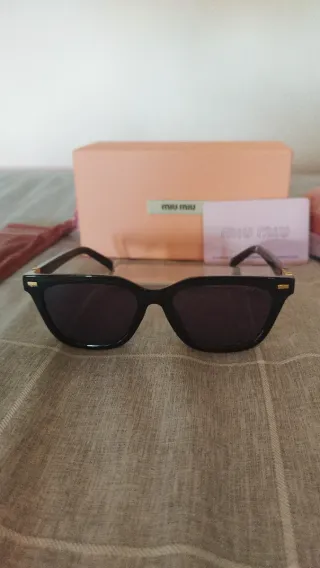 Gafas de sol Miu Miu negras y doradas mujer